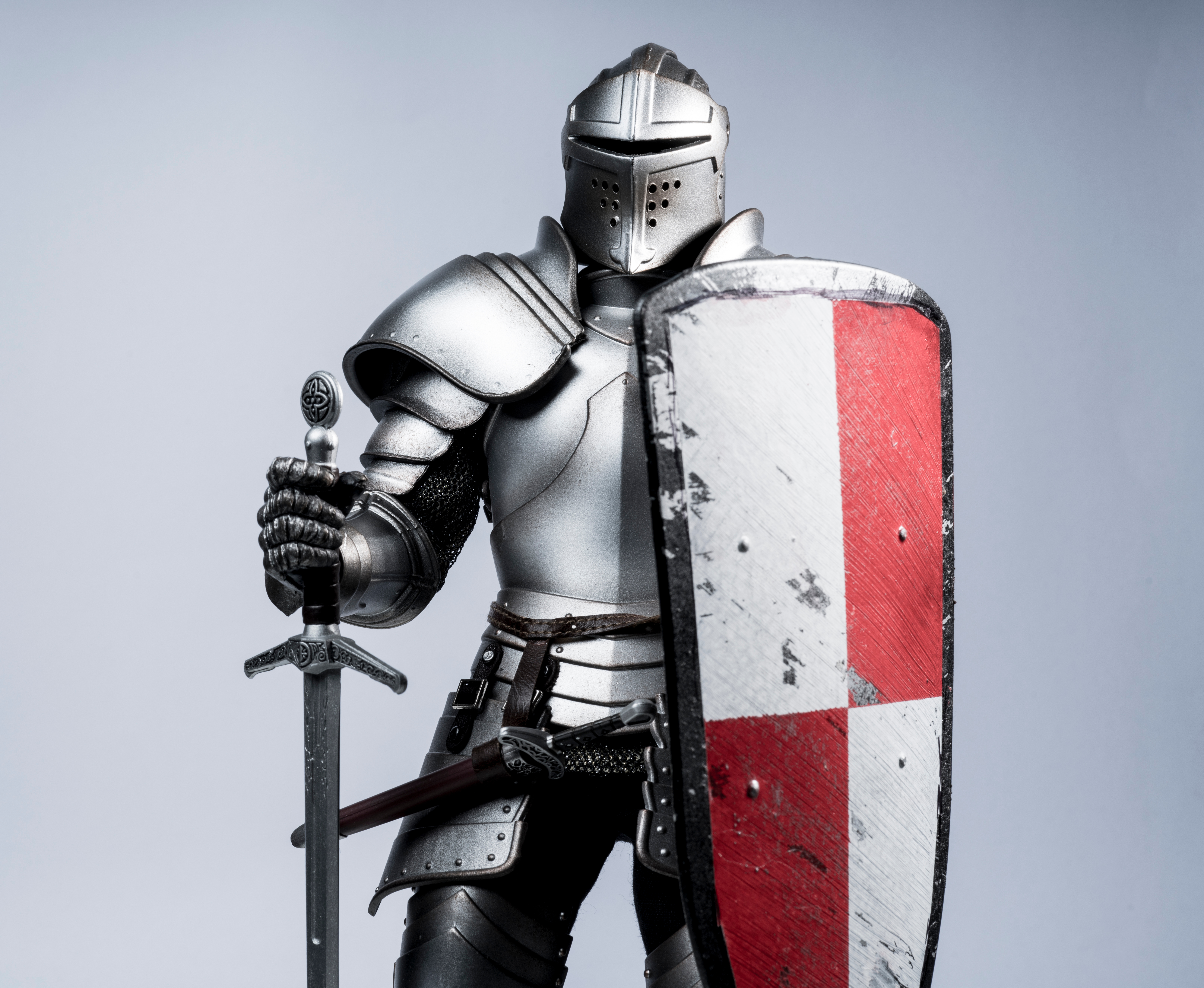 Medieval knight holding sword and shield with red cross